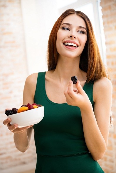Young happy smiling woman with plate of fruits, indoors. Beauty and dieting concept. Weight lossing, by healthy eating.